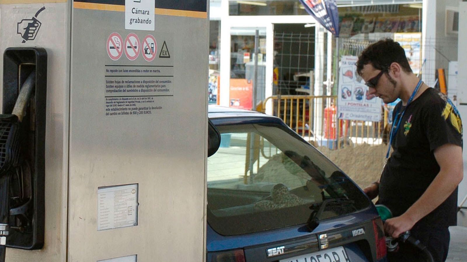 Imagen de archivo de un joven repostando en una gasolinera