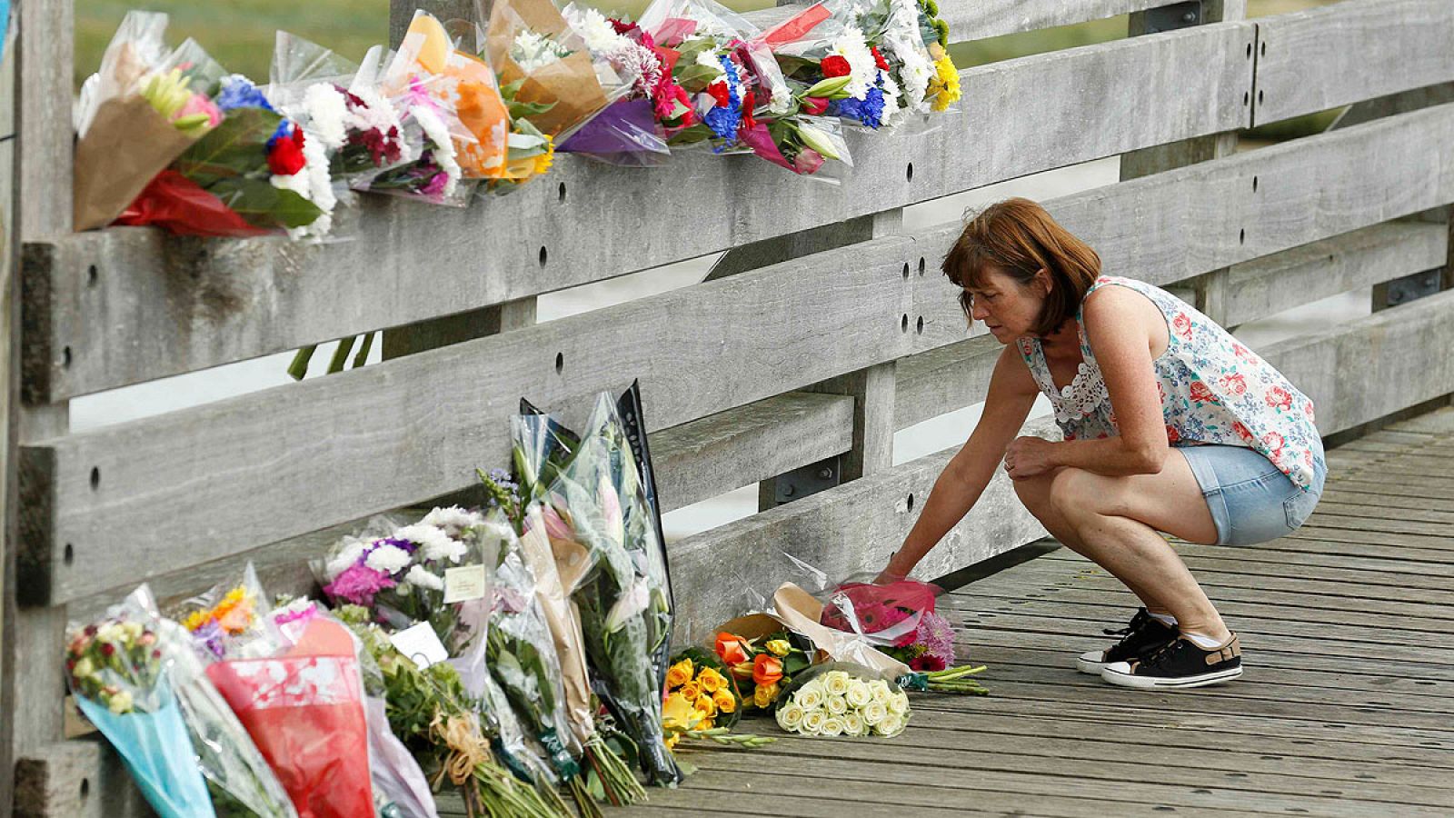 Una mujer deposita flores en Shoreham cerca del lugar del accidente