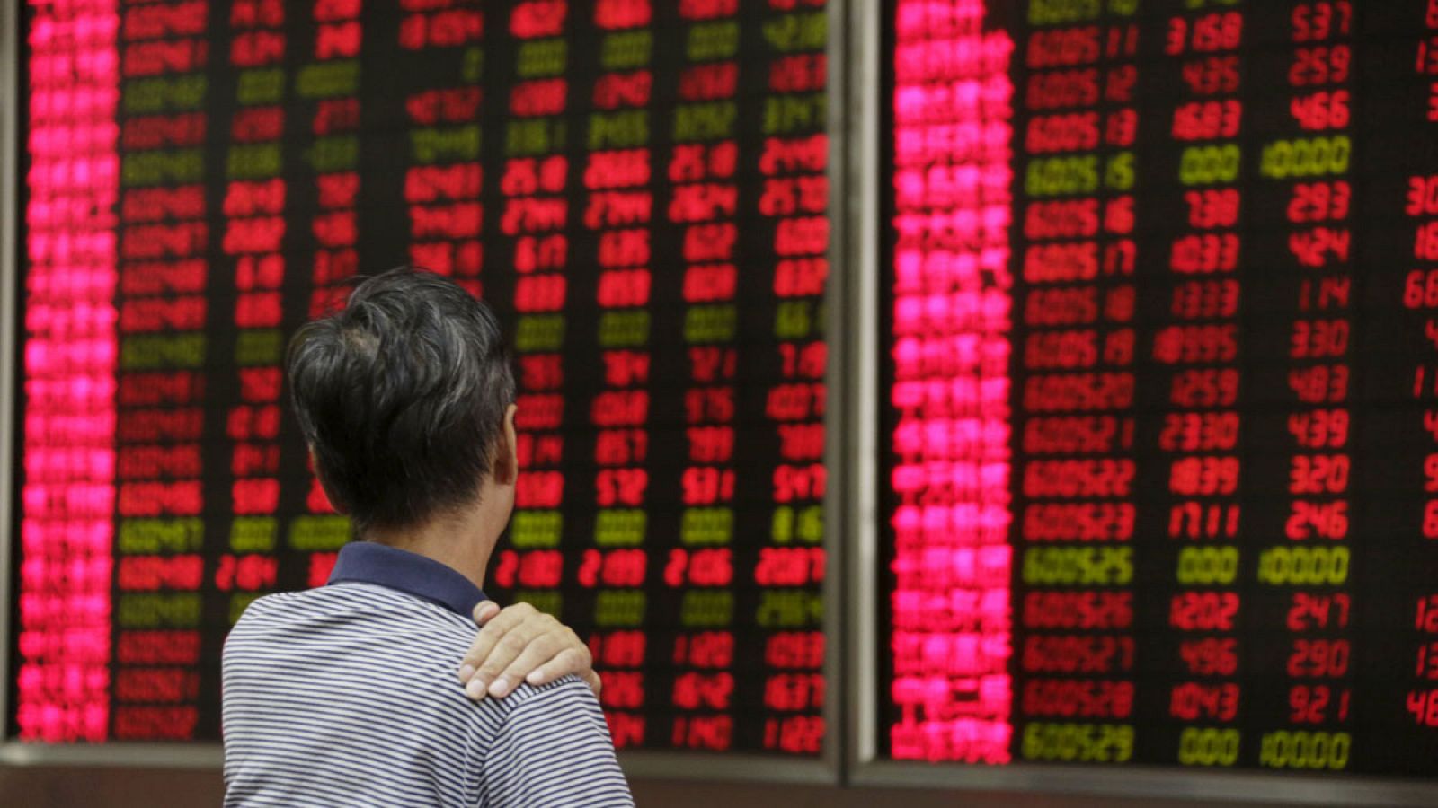 Un inversor, atento a la pantalla de cotizaciones en una casa de valores de Pekín