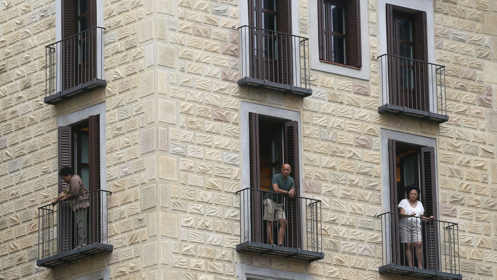 Varias personas se asoman al balcón en el barrio gótico de Barcelona