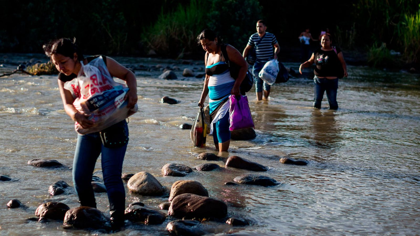 Un grupo de venezolanos cruza el río Táchira, frontera con Colombia. 