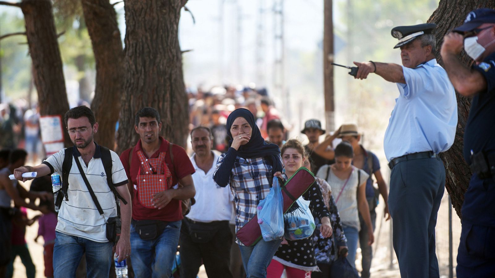 Un grupo de inmigrantes cruzan al frontera entre Grecia y Macedonia.