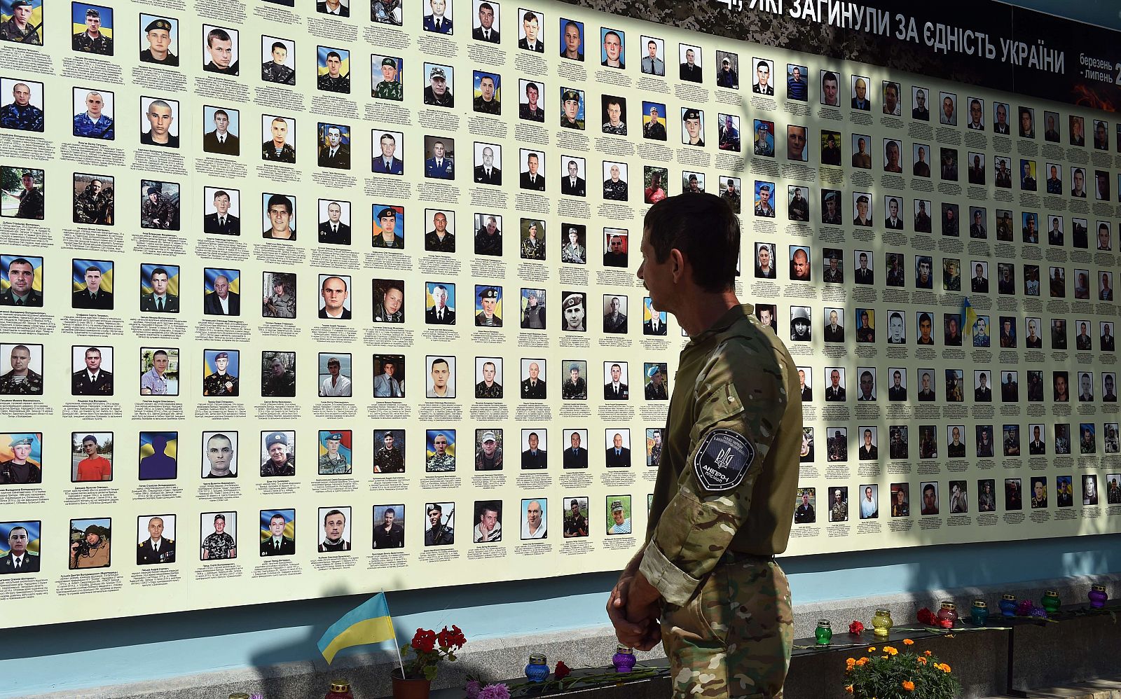 Un militar mira las fotos de sus compañeros fallecidos en combate en un memorial en Kiev.