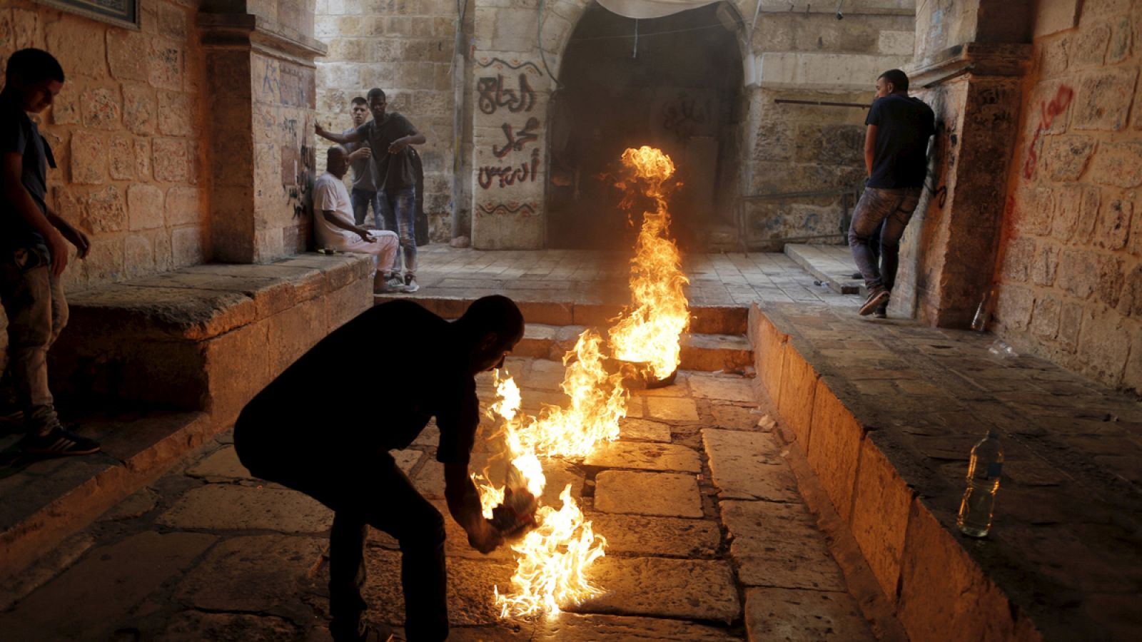 Un manifestante palestino prende fuego a un neumático en el casco antiguo de Jerusalen