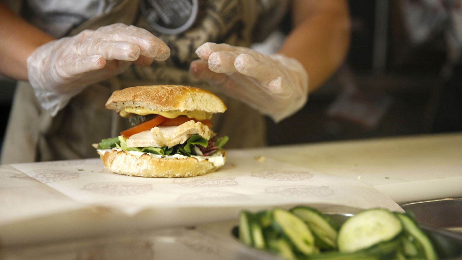 Una empleada prepara un bagel en una cafetería de París