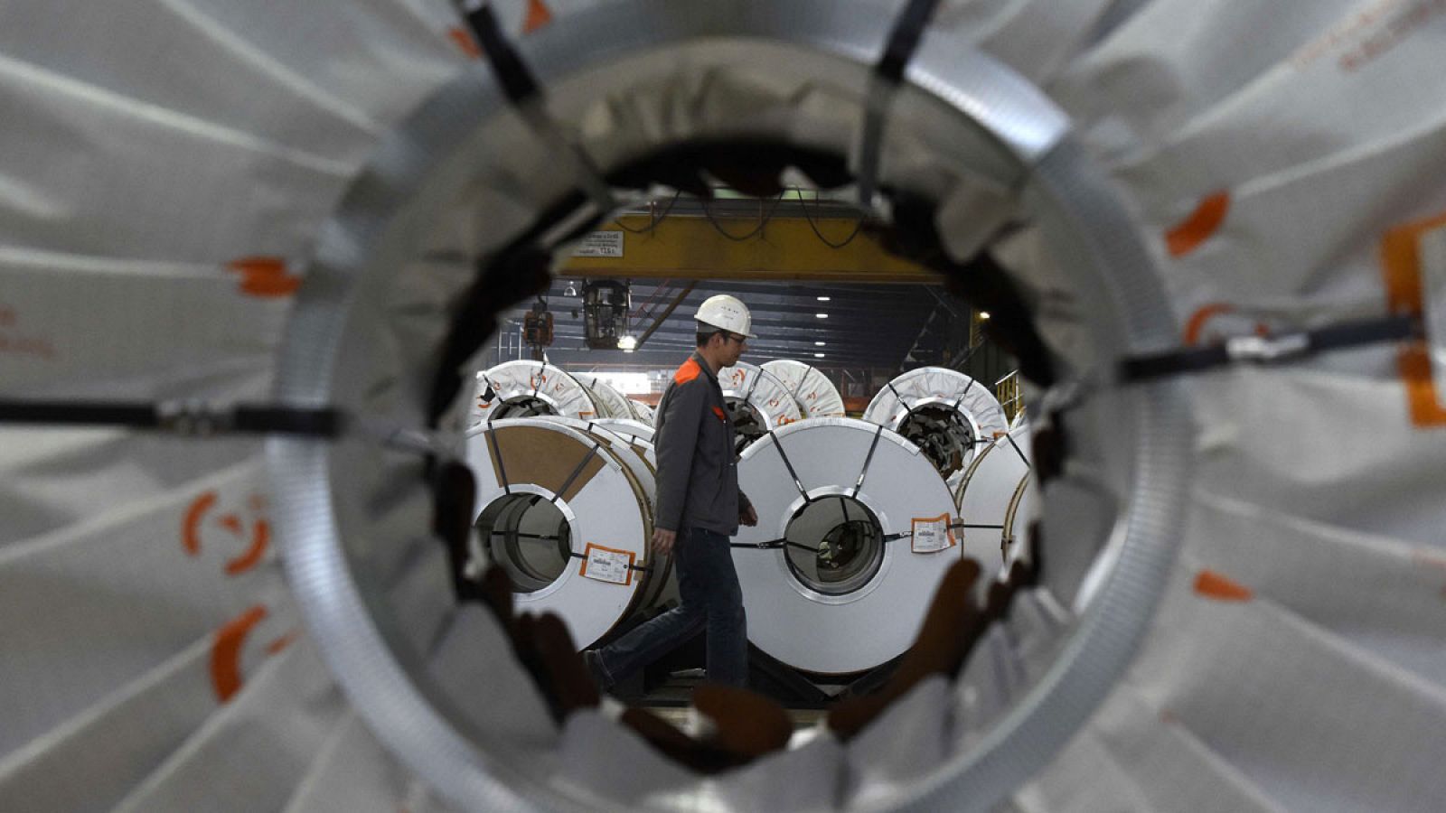 Un empleado, visto a través de los tubos fabricados en una planta de la acería alemana Salzgitter