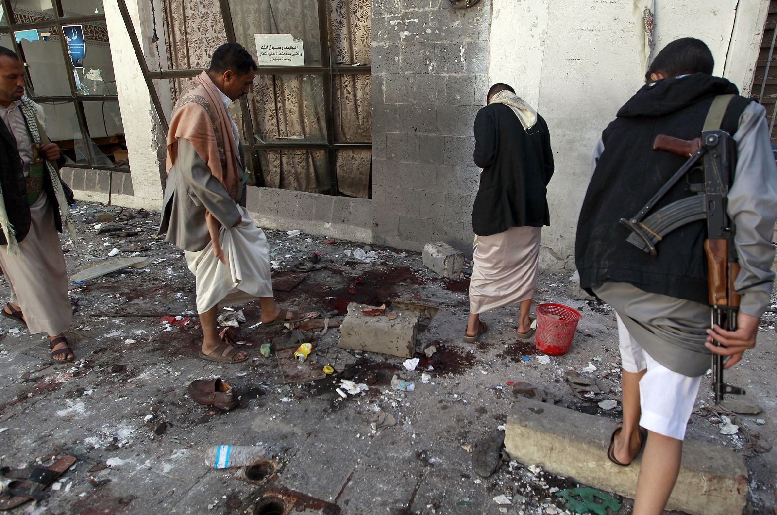 Rebeldes hutíes revisan los destrozos en la mezquita Billi, tras la explosión de dos bombas durante el rezo del viernes.