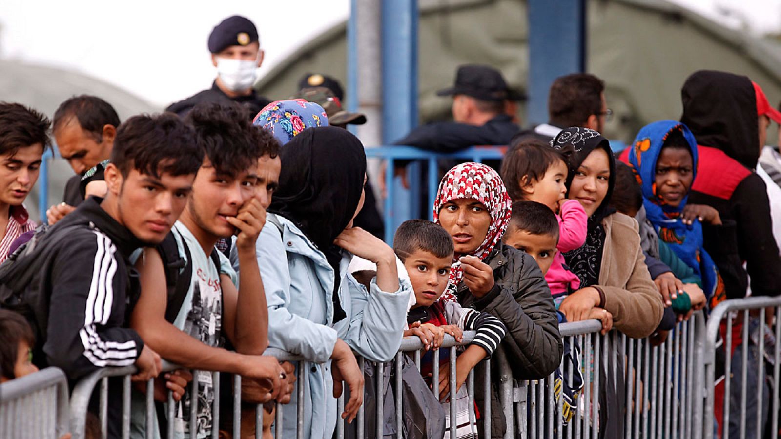 Varias personas esperan en un campo de refugiados cerca de la frontera con Serbia, en Opatovac, Croacia.