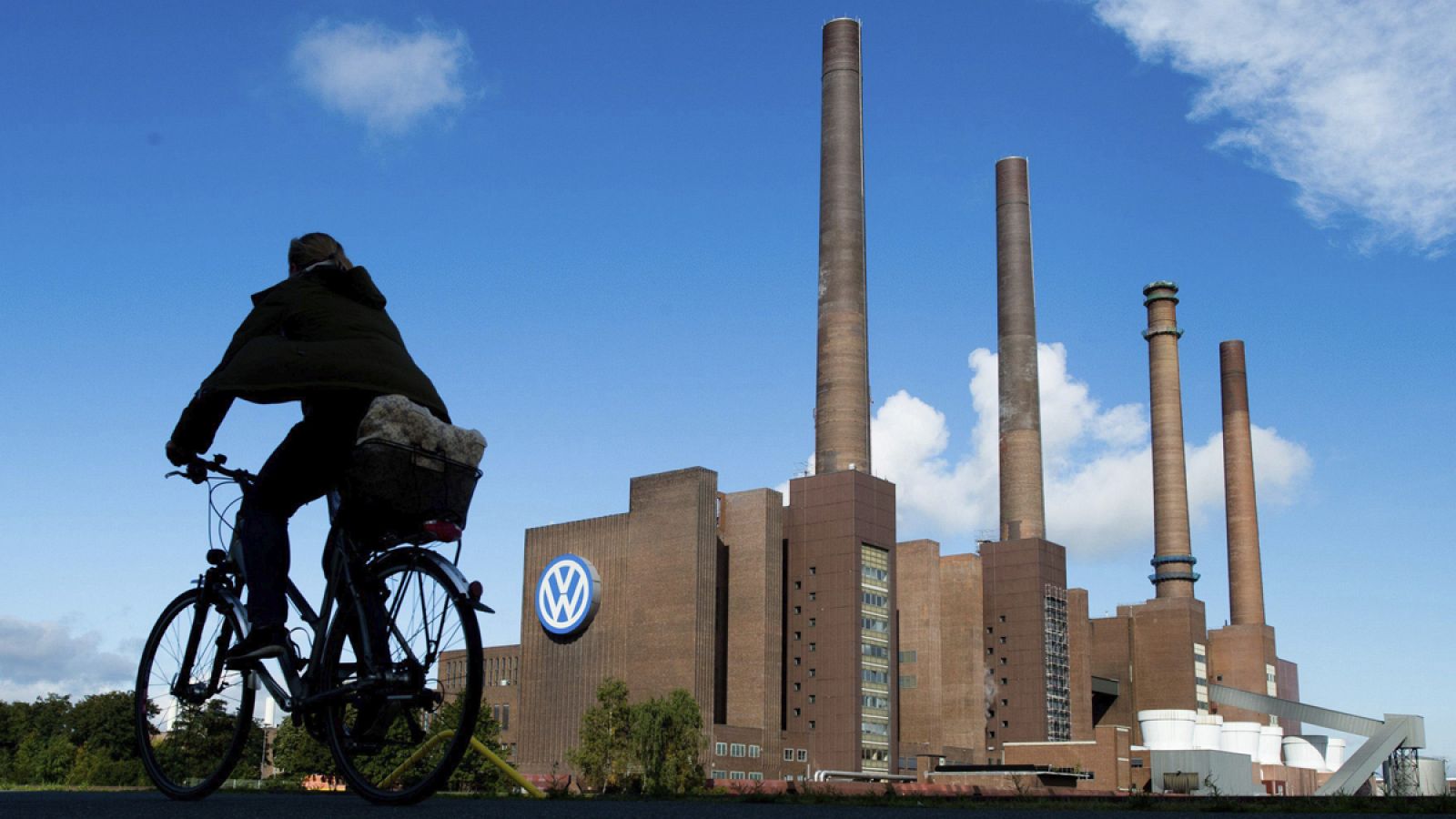 Un ciclista pasa por delante de la planta de Volkswagen en Wolfsburgo