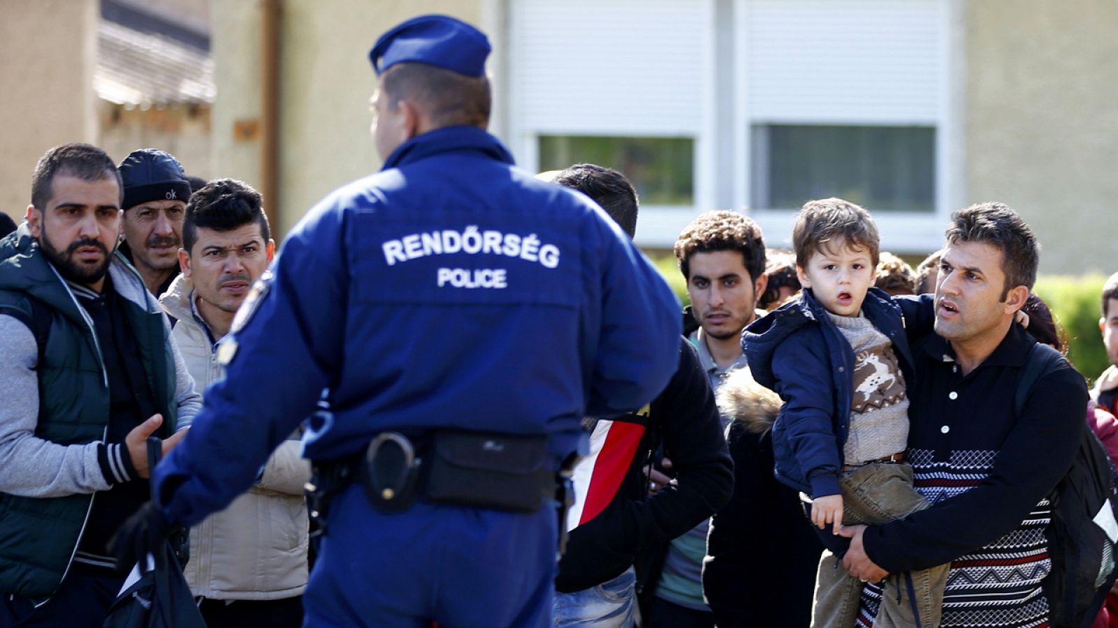 Un policía húngaro dirige a migrantes hacia la frontera con Austria