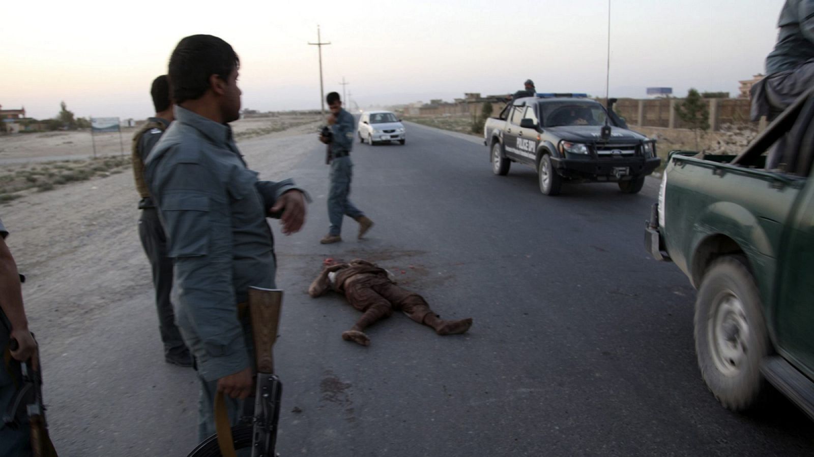 Soldados afganos permanecen junto al cadáver de un supuesto talibán durante la contraofensiva para recuperar el control de Kunduz
