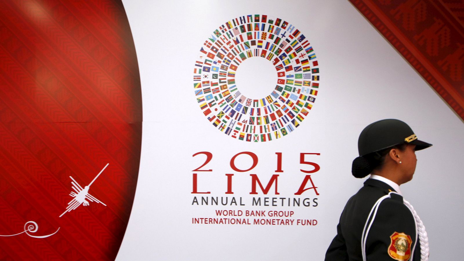 Una policía pasa por delante del panel que anuncia la reunión del FMI en Lima