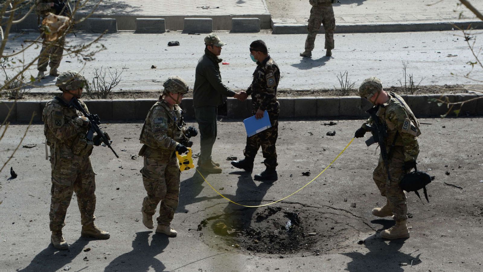 Soldados de la OTAN inspeccionan la zona donde ha explosionado el coche bomba
