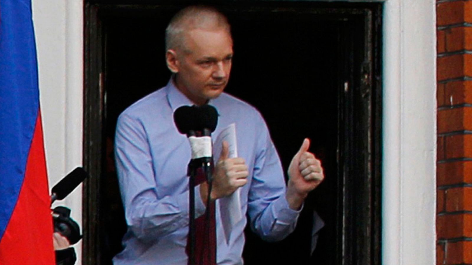 El fundador de Wikileaks, Julian Assange, saluda a la prensa desde la embajada de ecuadro en Londres.
