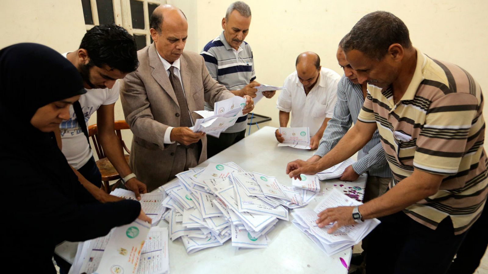 Un grupo de personas recuenta los votos en el segundo día de elecciones parlamentarias en Egipto en un punto de votación en una escuela de Giza.