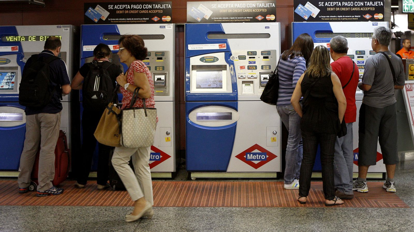 Viajeros en las máquinas expendedoras de billetes en la estación de Sol.