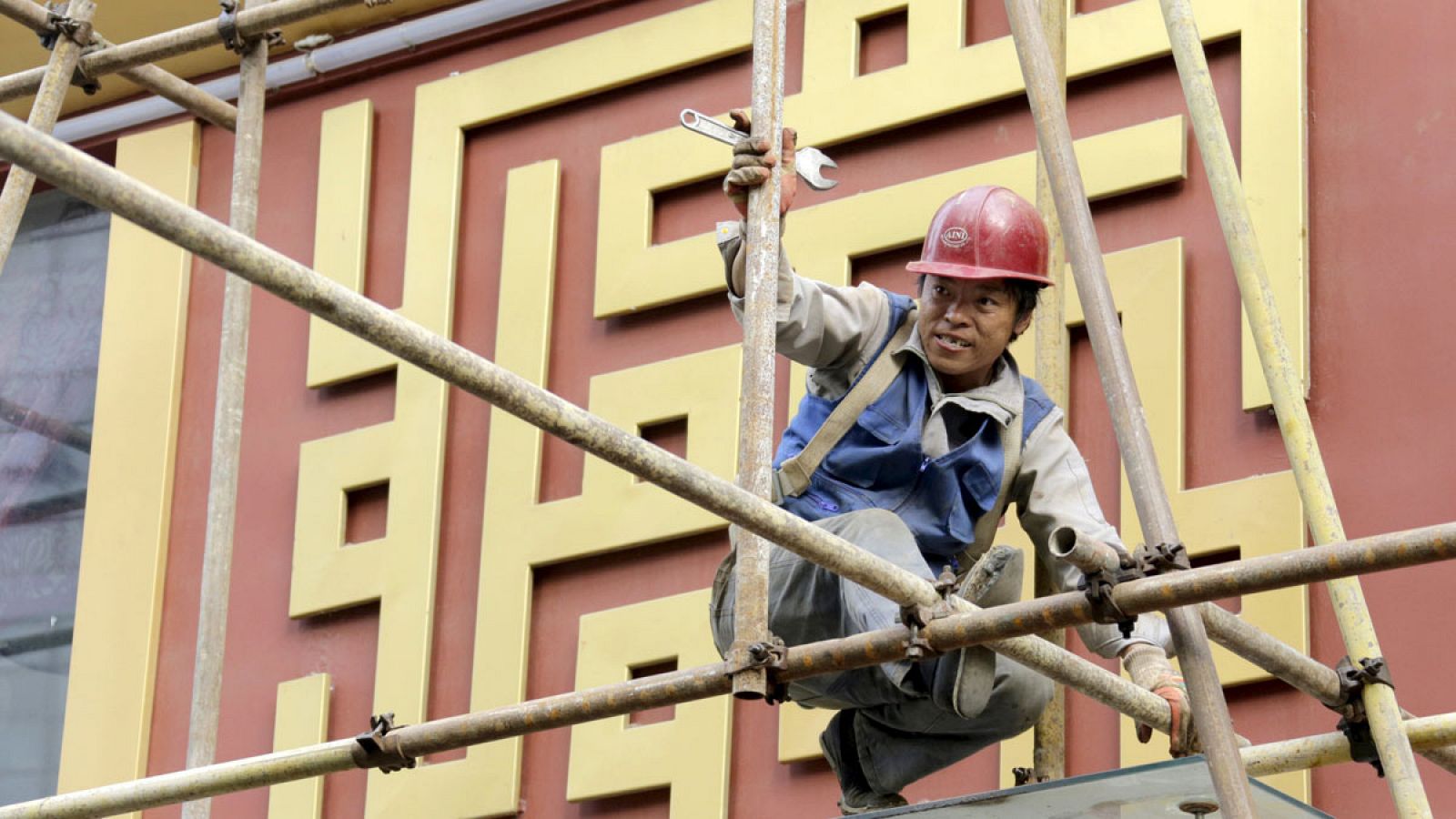 Un trabajador sobre un andamio en una obra de construcción en el centro de Pekín