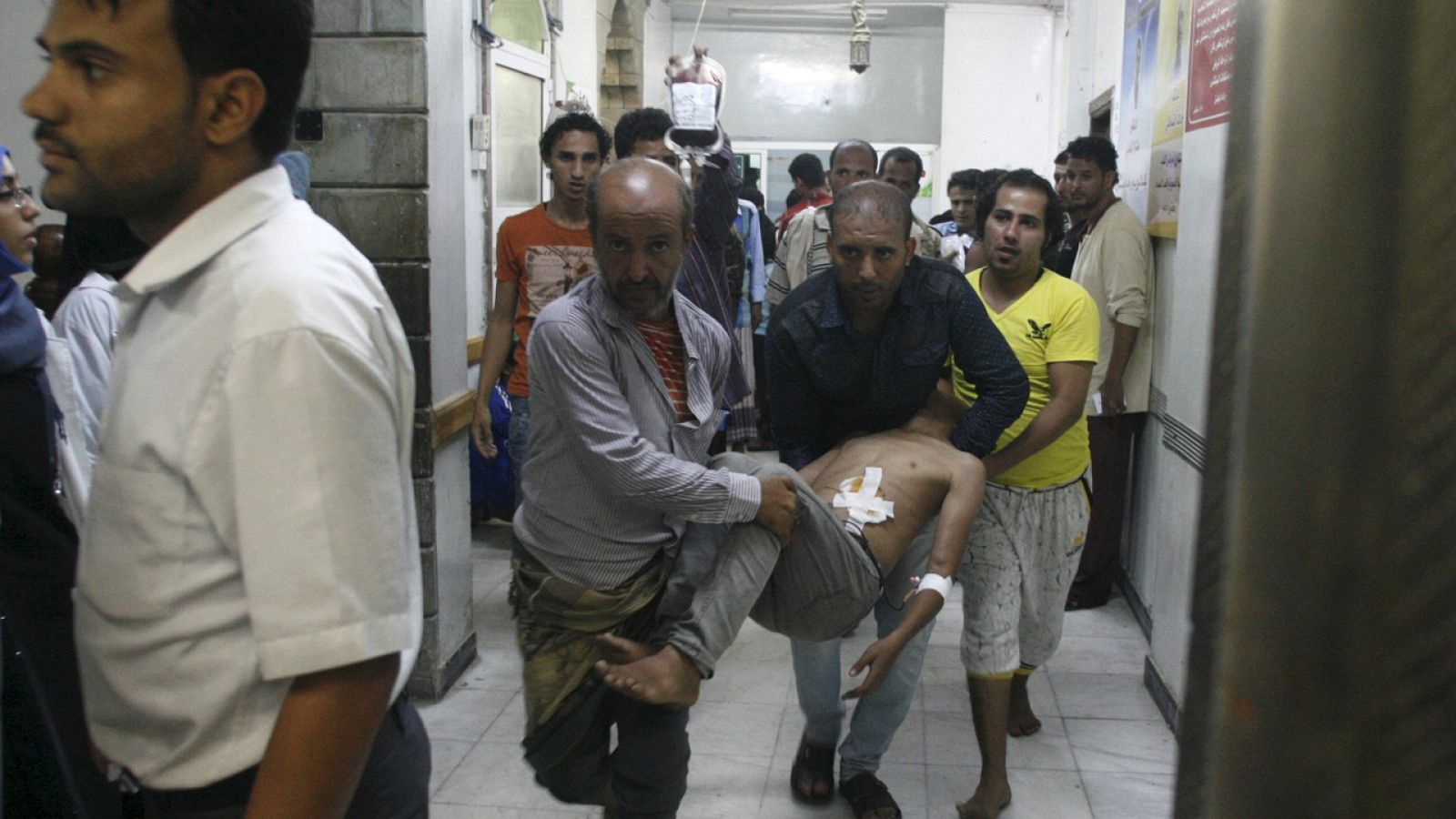 People carry a man at a hospital after he was injured by a shelling during clashes between Houthi militants and pro-government militants in Yemen's southwestern city of Taiz