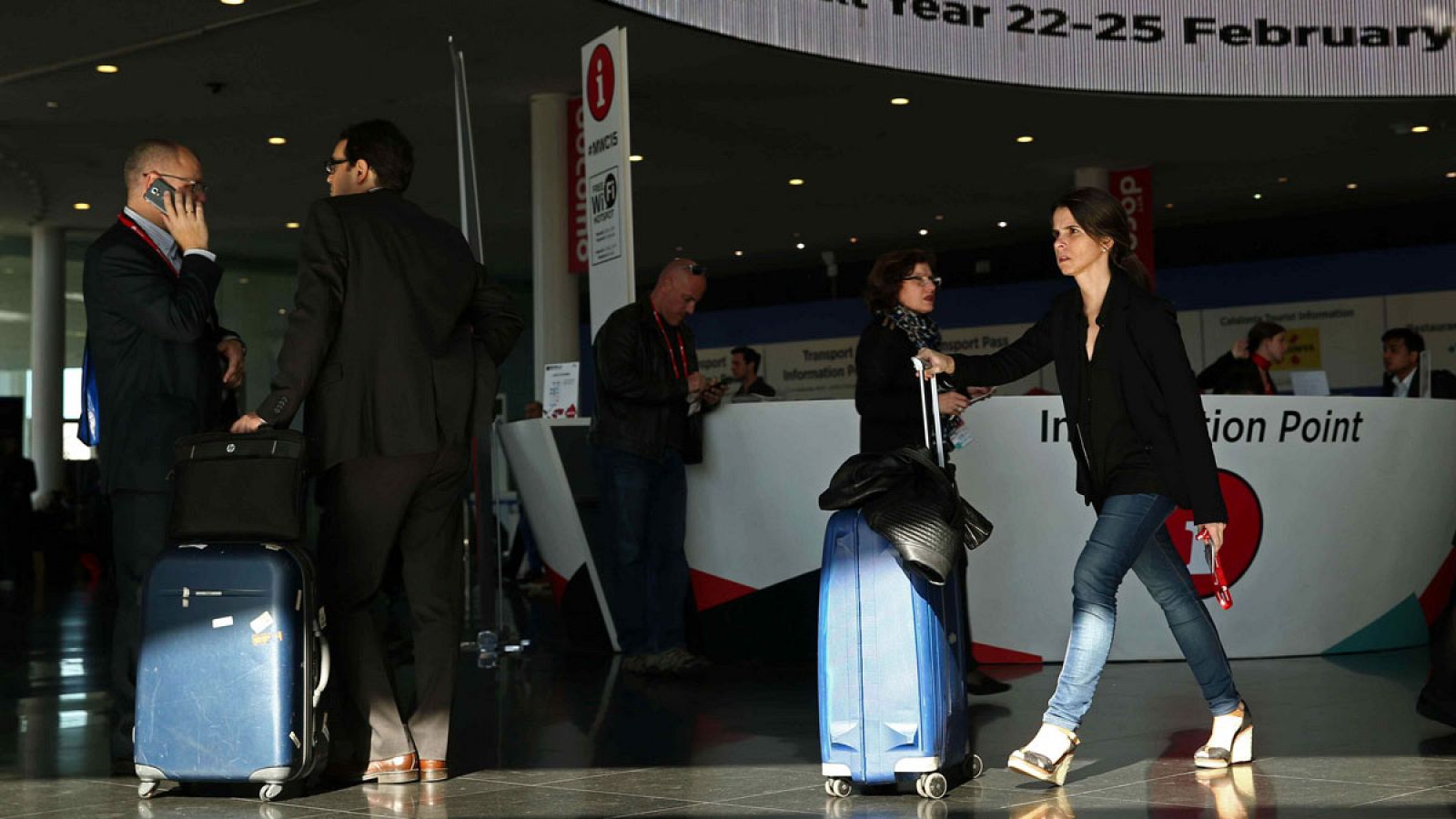 Varios viajeros con equipajes en un punto de información de Barcelona