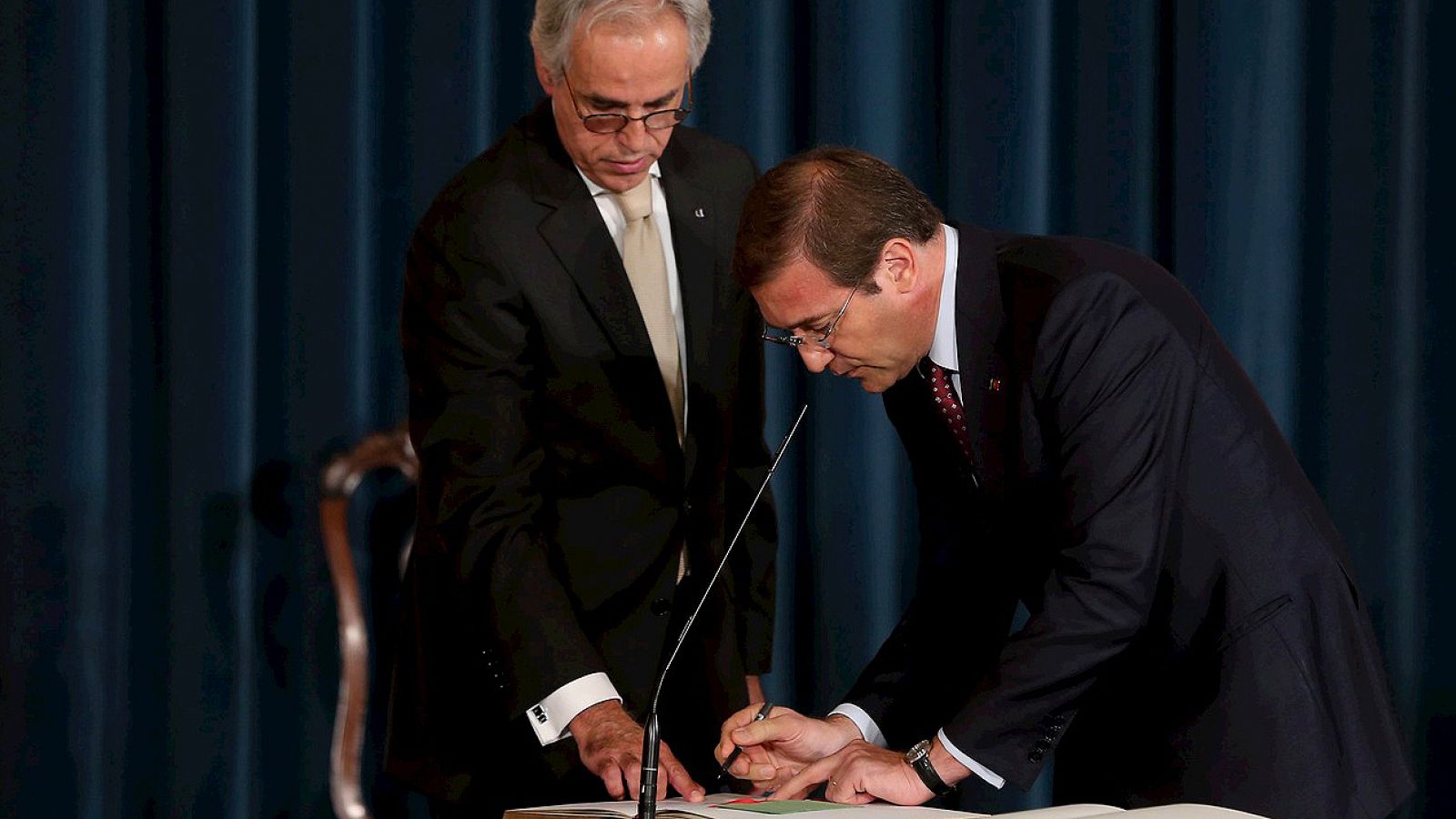 El primer ministro portugués, Pedro Passos Coelho (d), firma durante la ceremonia de su investidura celebrada en el Palacio de Ajuda en Lisboa (Portugal), 30 de octubre de 2015.  EFE/Tiago Petinga