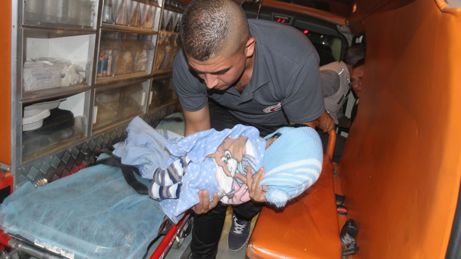 Un sanitario transporta en brazos el cuerpo del bebé palestino Ramadan Thawabteh