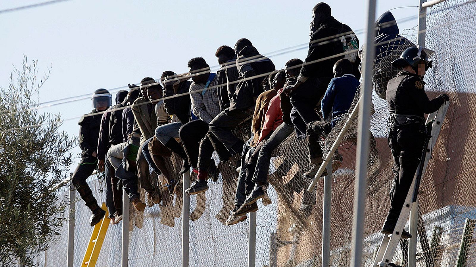 Varios inmigrantes encaramados en la valla entre Melilla y Marruecos
