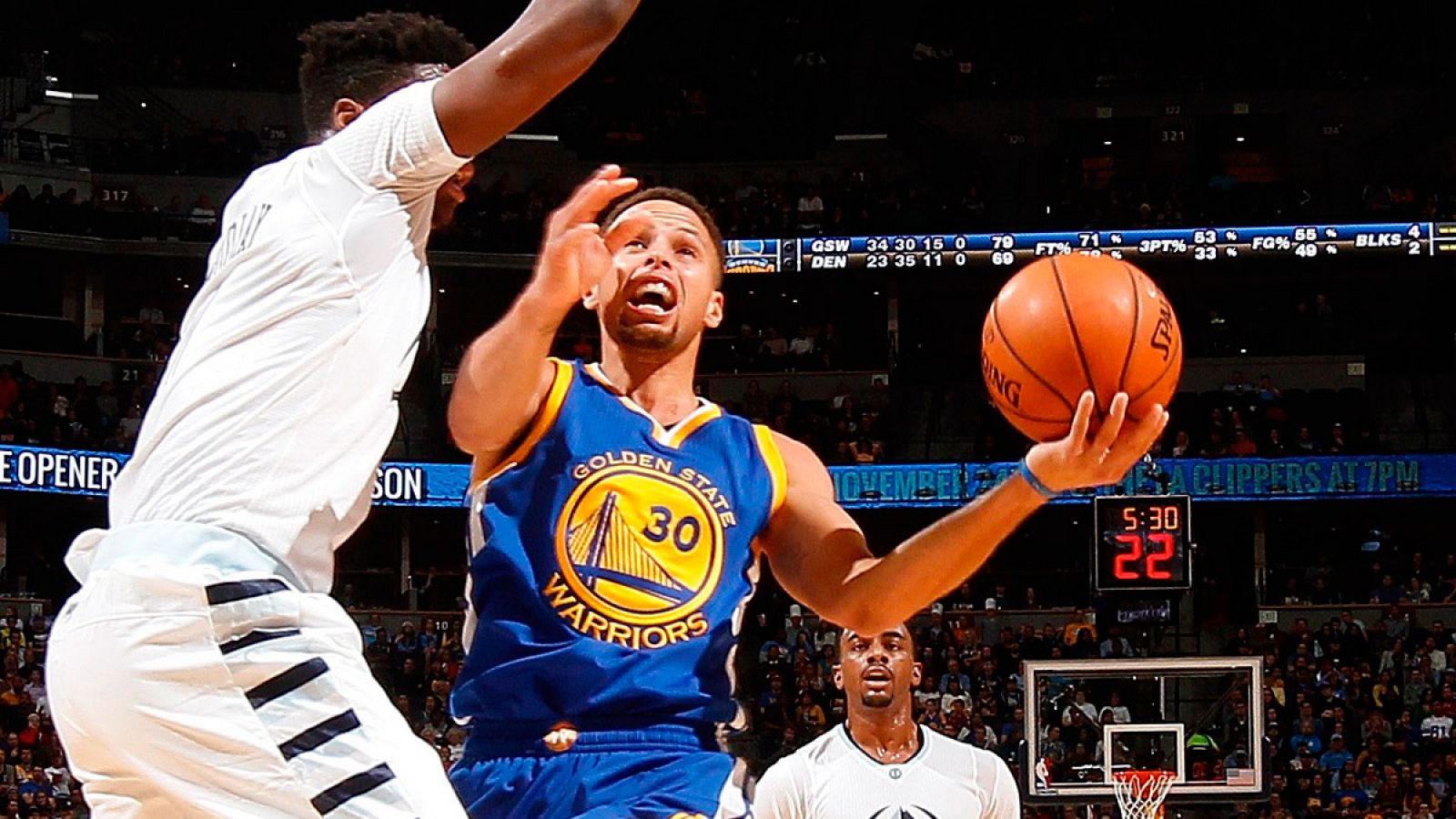 El jugador de los Warriors de Golden State, Stephen Curry, lanza un tiro contra Emmanuel Mudiay de los Denver Nuggets.