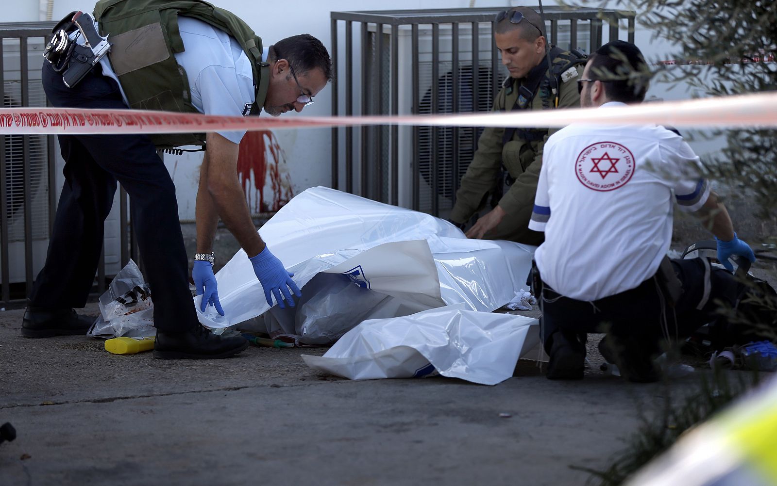 Los servicios de emergencia israelíes retiran el cadáver de un israelí apuñalado por un palestino en una gasolinera de Cisjordania