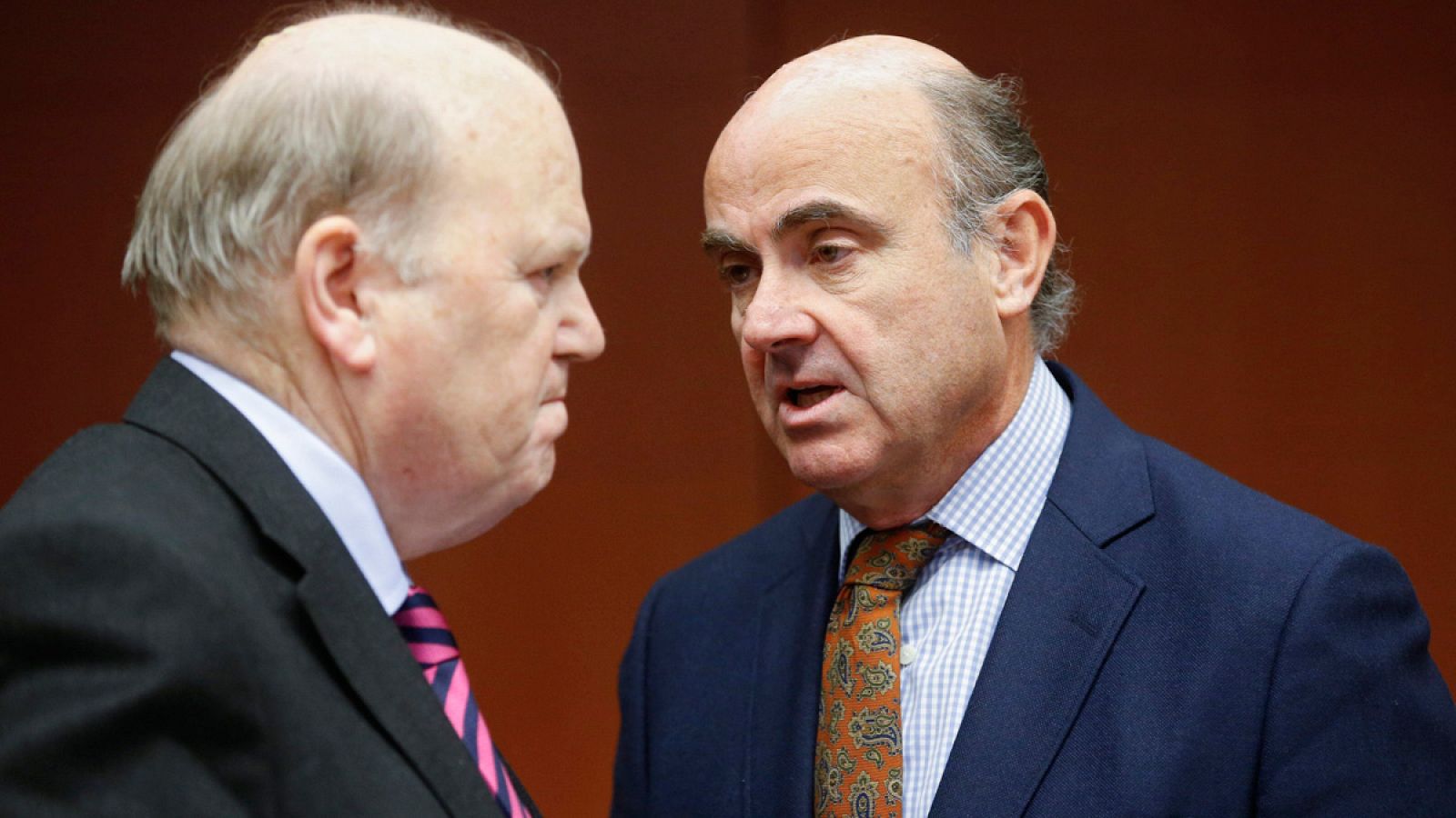 El ministro de Finanzas de Irlanda, Michael Noonan, conversa con el ministro de Economía de España, Luis de Guindos, durante la reunión del Eurogrupo