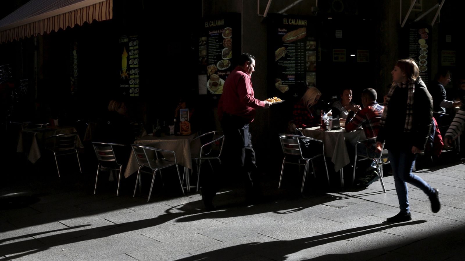 Un camarero sirve una mesa en una terraza del centro de Madrid