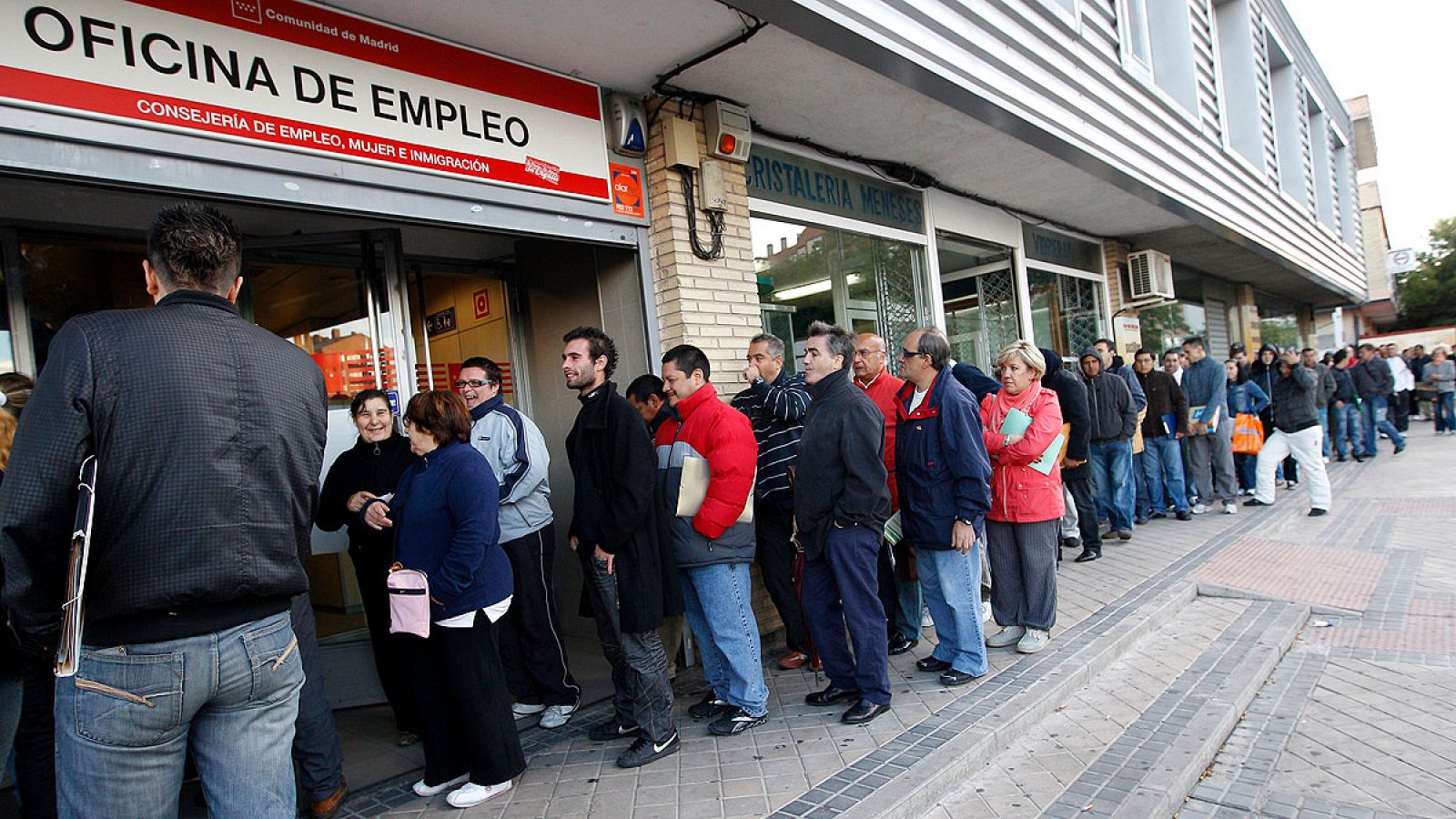 Cola de personas esperando su turno en una oficina de empleo de un barrio de Madrid