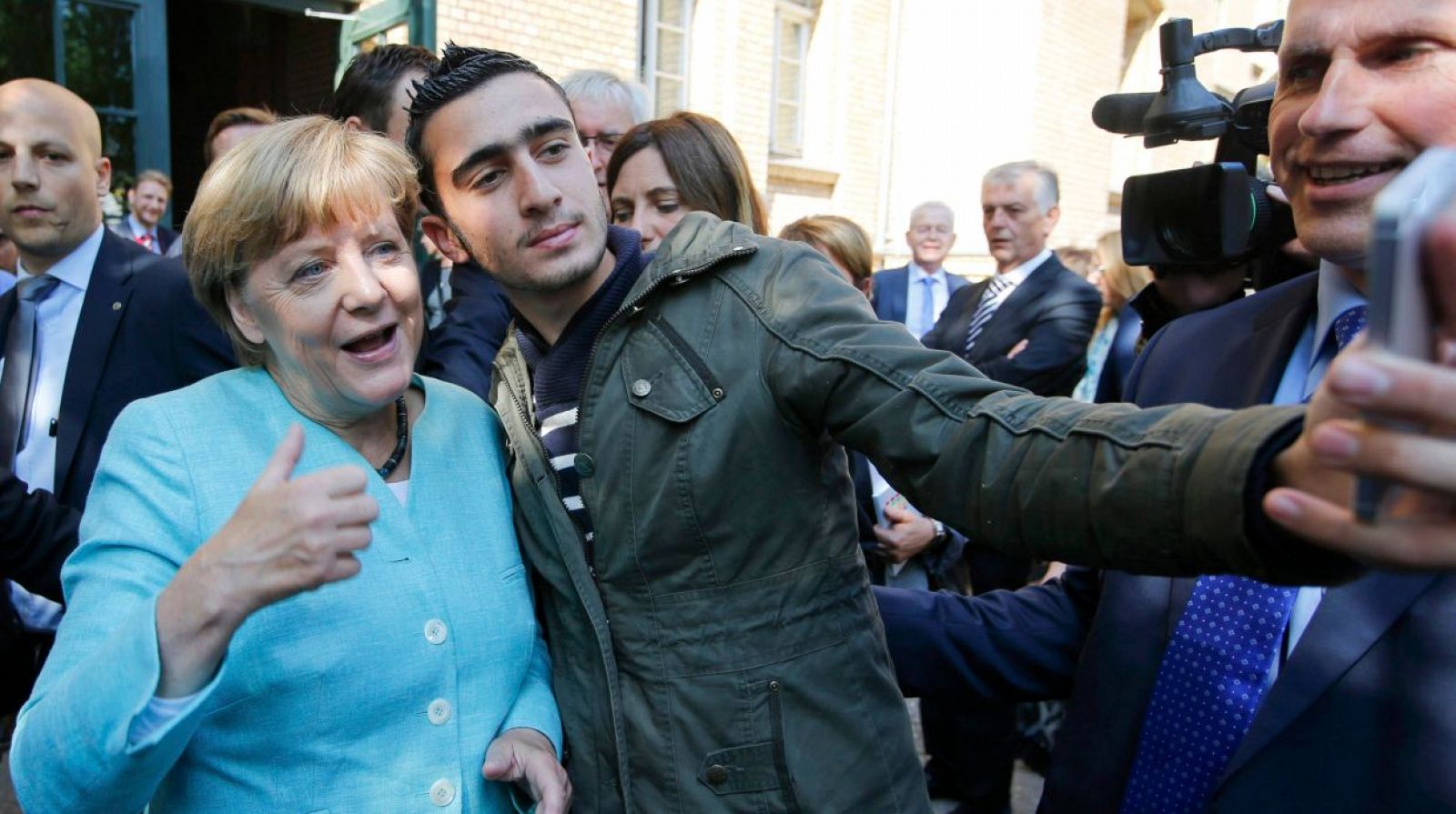 Merkel se hace un 'selfie'con un refugiado a la salida de un centro de acogida.