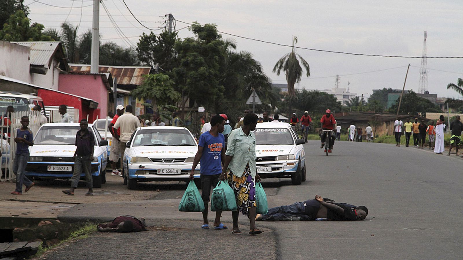 Vecinos caminan entre cadáveres sin identificar tras los enfrentamientose en la capital de Burundi.
