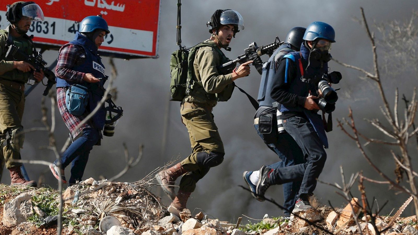 Periodistas hacen su trabajo entre soldados israelíes durante enfrentamientos en Silwad, Cisjordania ocupada. AFP PHOTO / ABBAS MOMANI / AFP / ABBAS MOMANI
