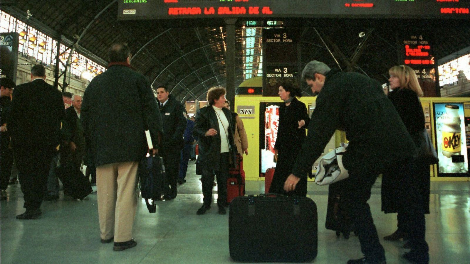 Un grupo de viajeros espera en una estación de tren