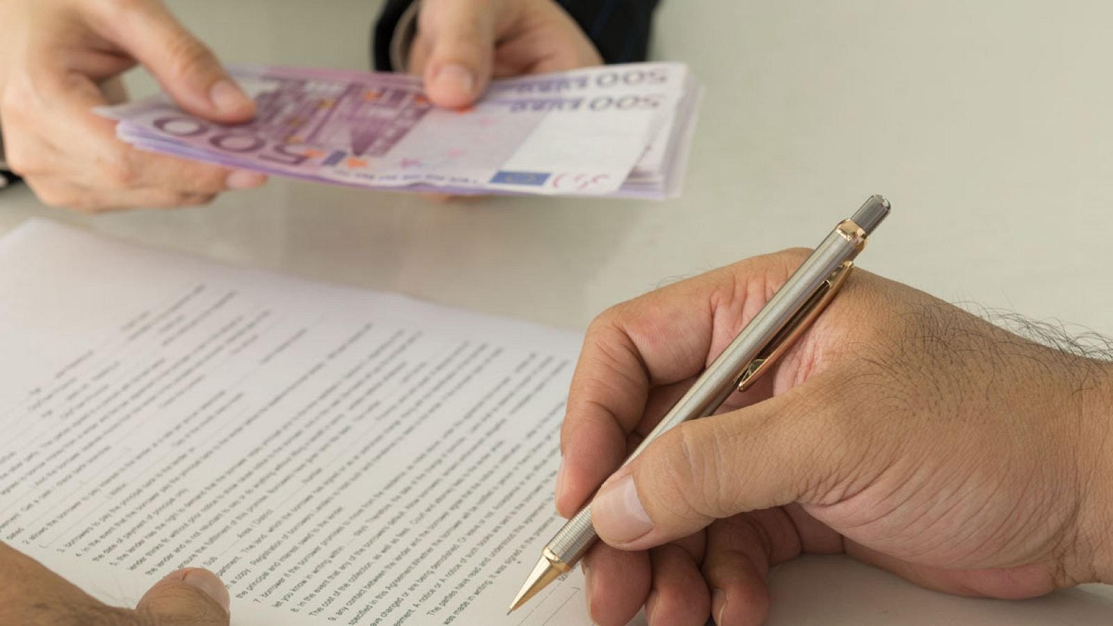 Un cliente firma un contrato de préstamo en una entidad