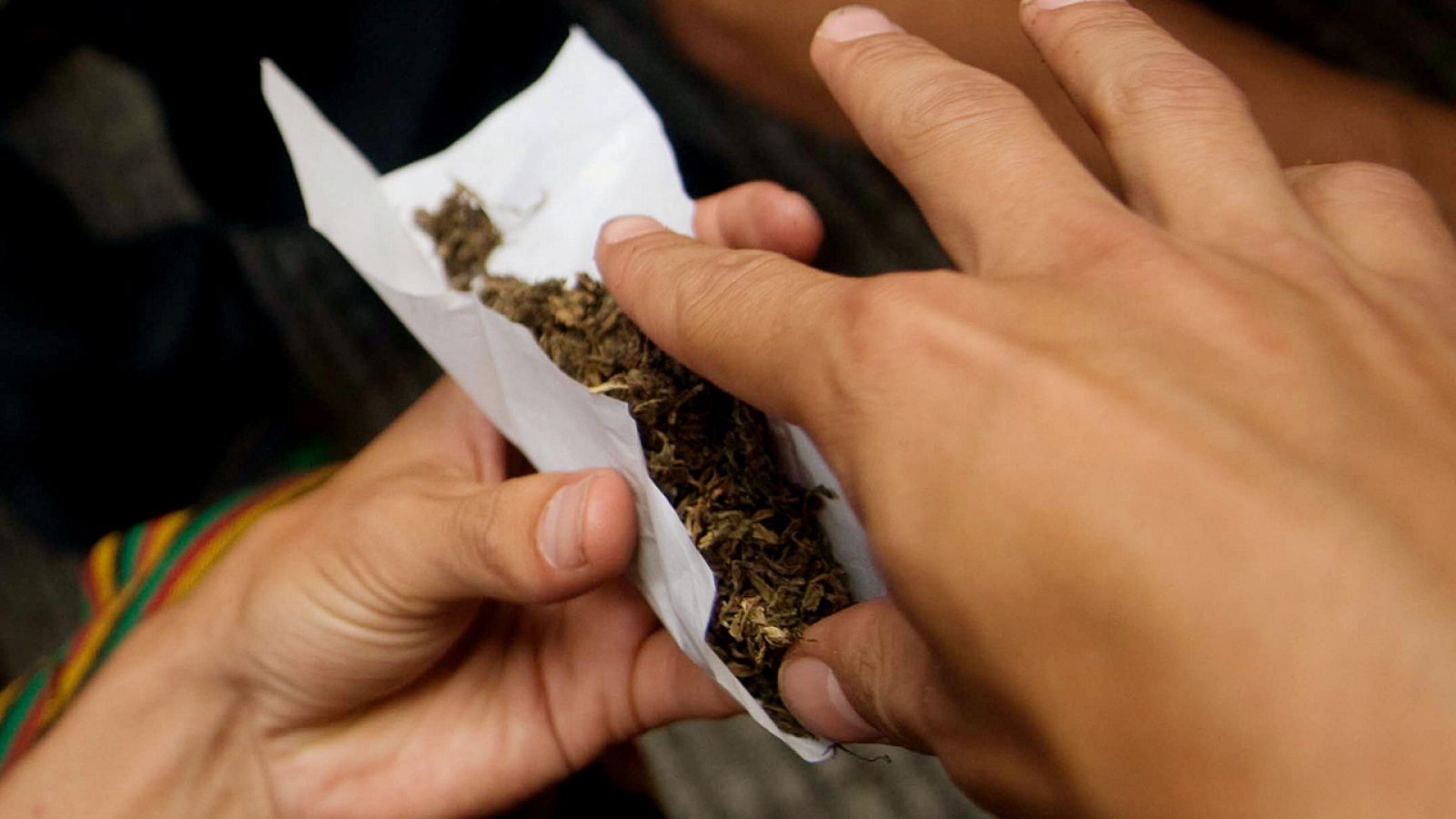 Un hombre lía un cigarrillo de marihuana en Medellín, Colombia (imagen de archivo)