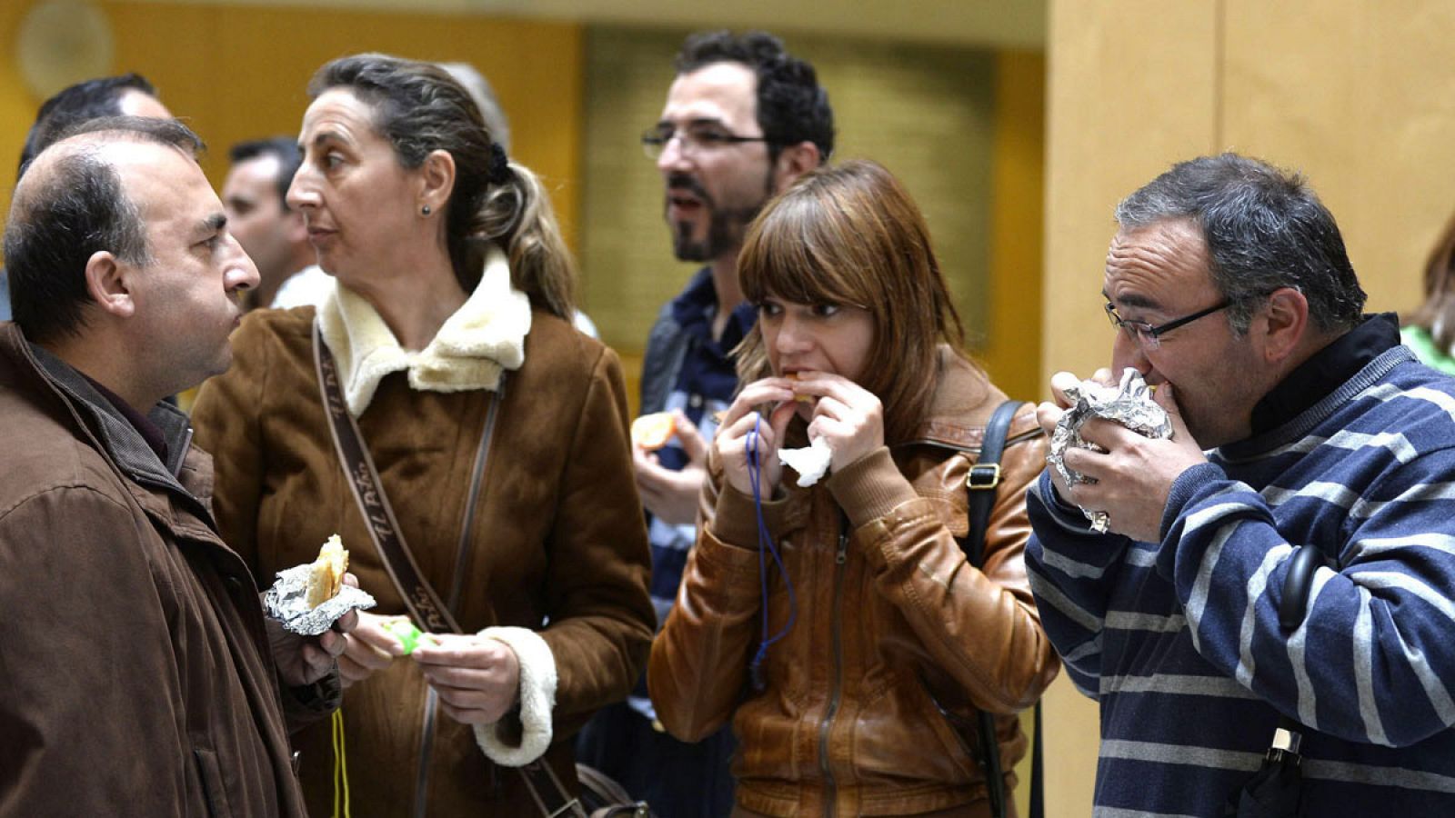 Un grupo de empleados toman un bocadillo a las puertas del trabajo