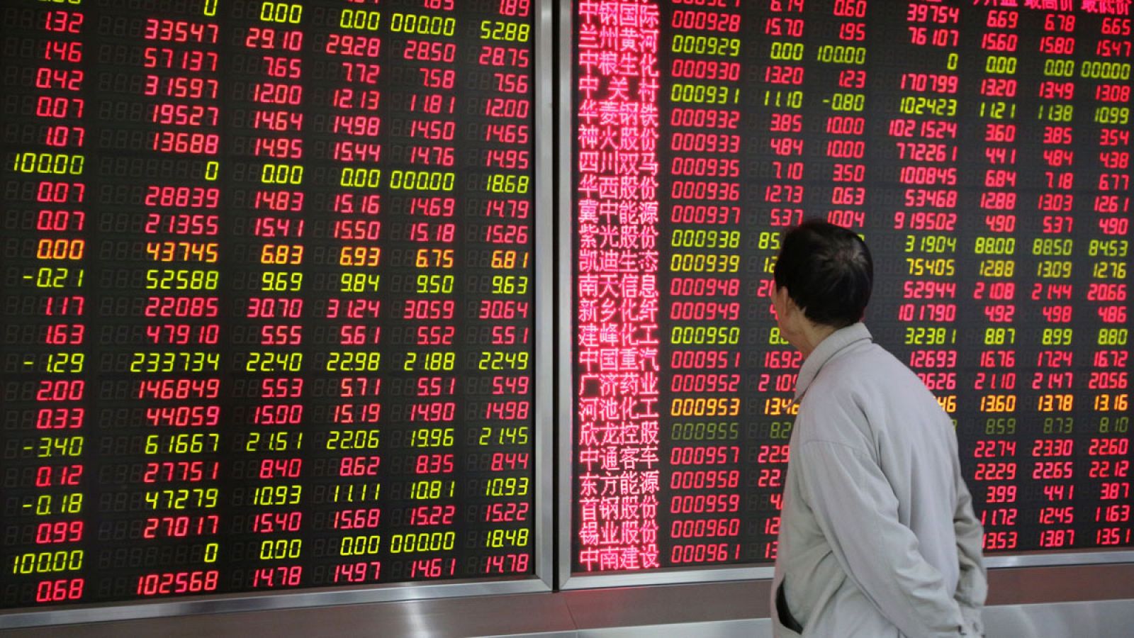 Un inversor observa un panel electrónico con información bursátil en Pekín, China.