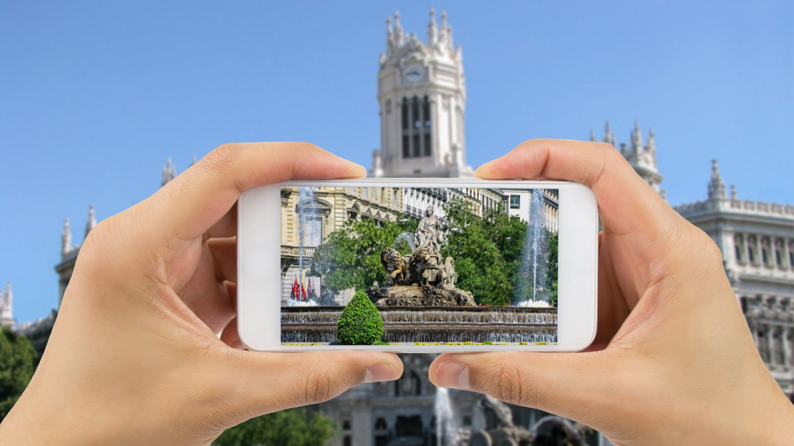 Un turista toma una foto de la Fuente de Cibeles en Madrid