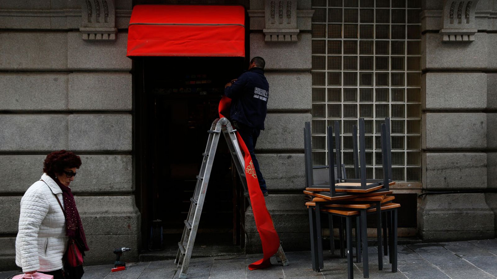 Un trabajador renueva la entrada de un restaurante en Madrid