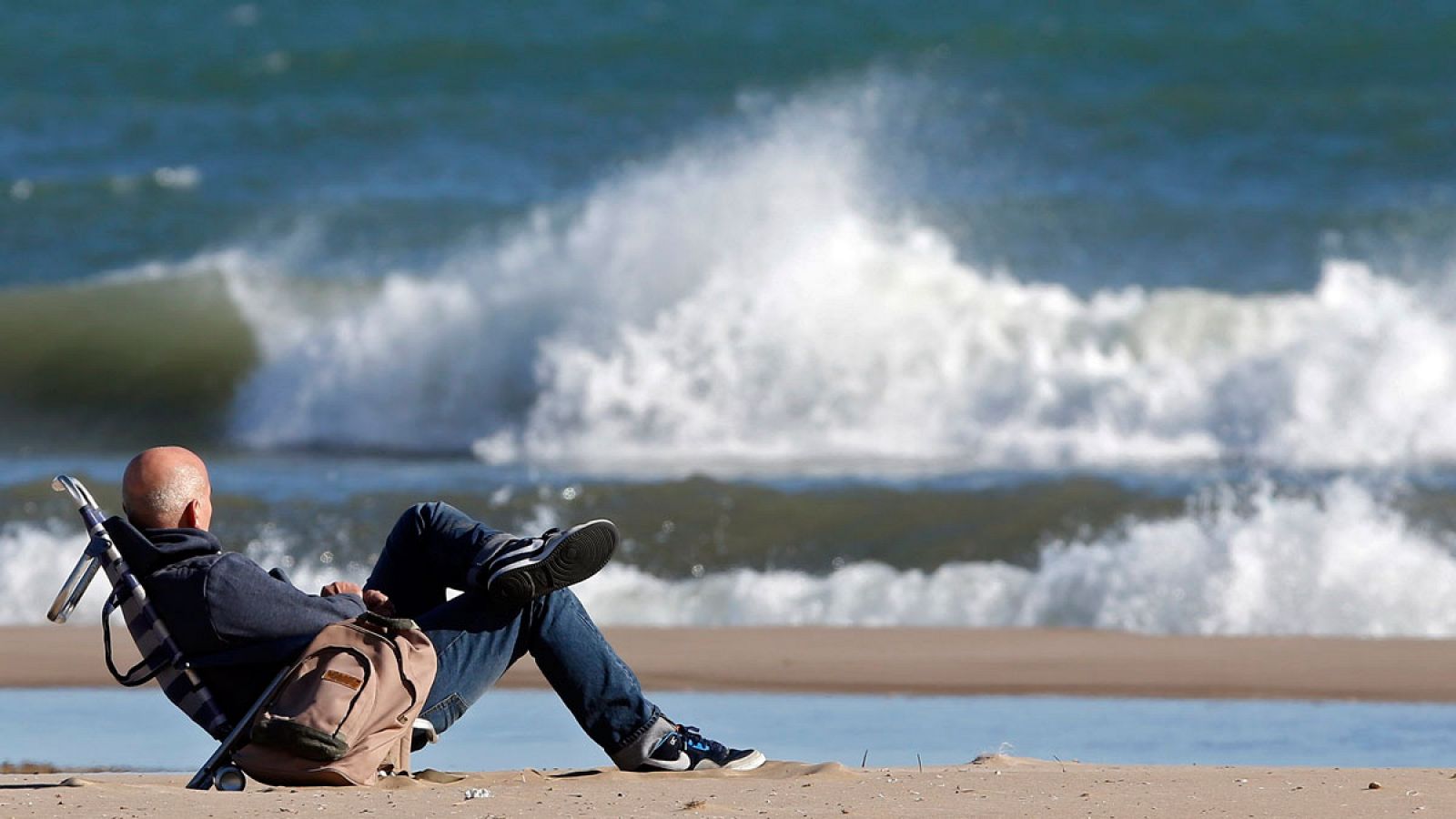 Un hombre contempla el mar picado en la playa de la Malvarrosa de Valencia.