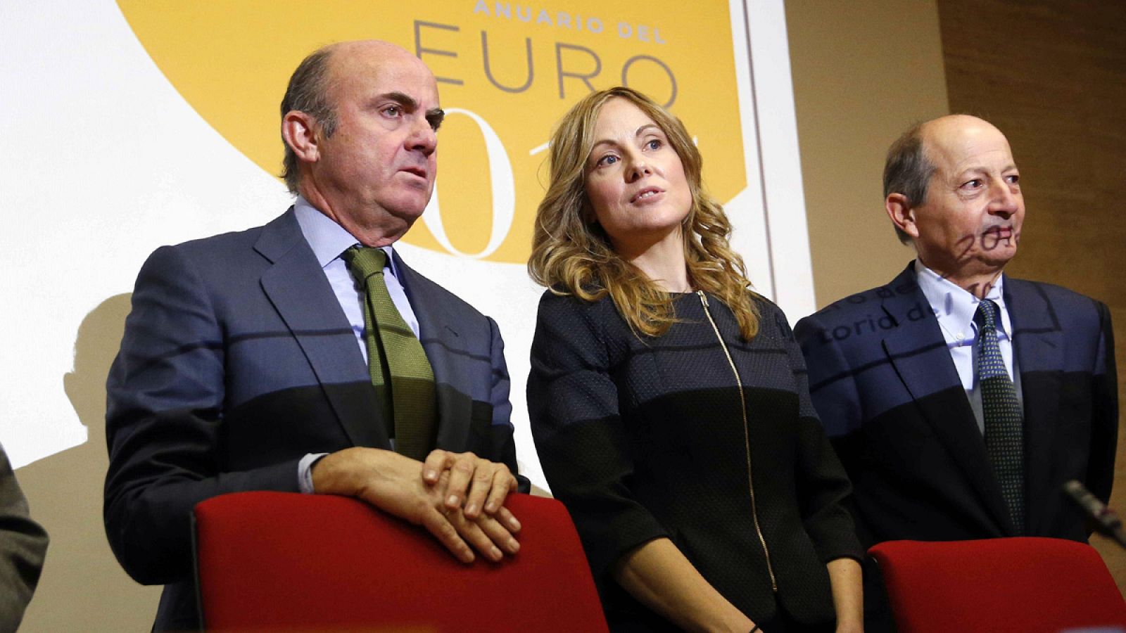 El ministro de Economía, Luis de Guindos, junto a la presidenta de la Fundación ICO, Emma Navarro, y el director del estudio, Fernando Fernández Méndez de Andés, durante la presentación del Anuario del Euro 2015 en la Fundación ICO