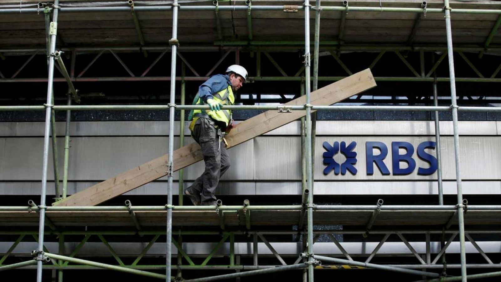 Un albañil camina por un andamio de un edificio en obras de renovación del Royal Bank of Scotland en Londres