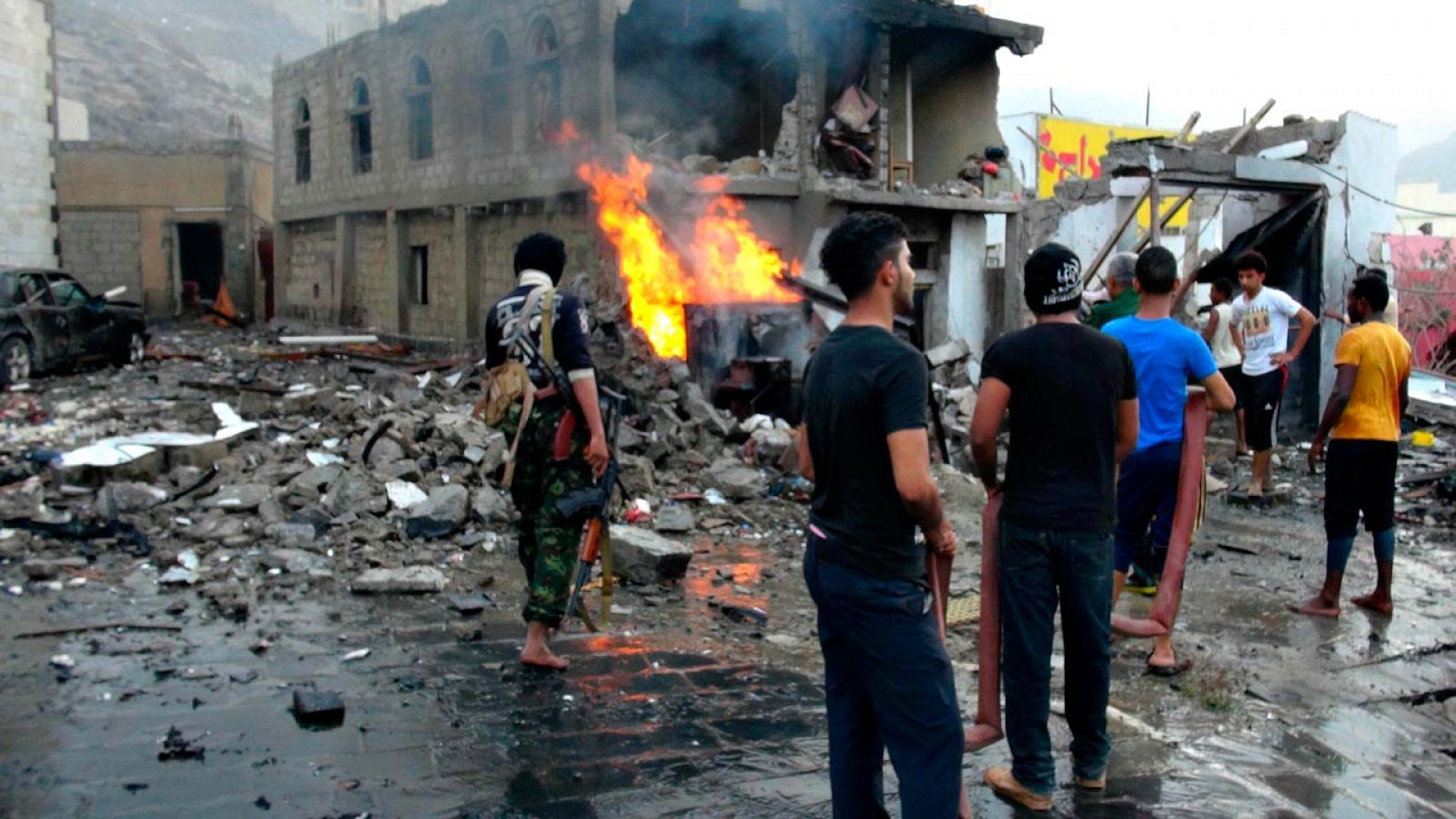 Un grupo de yemeníes observa los destrozos causados por el coche bomba que ha estallado cerca del palacio presidencial de Adén