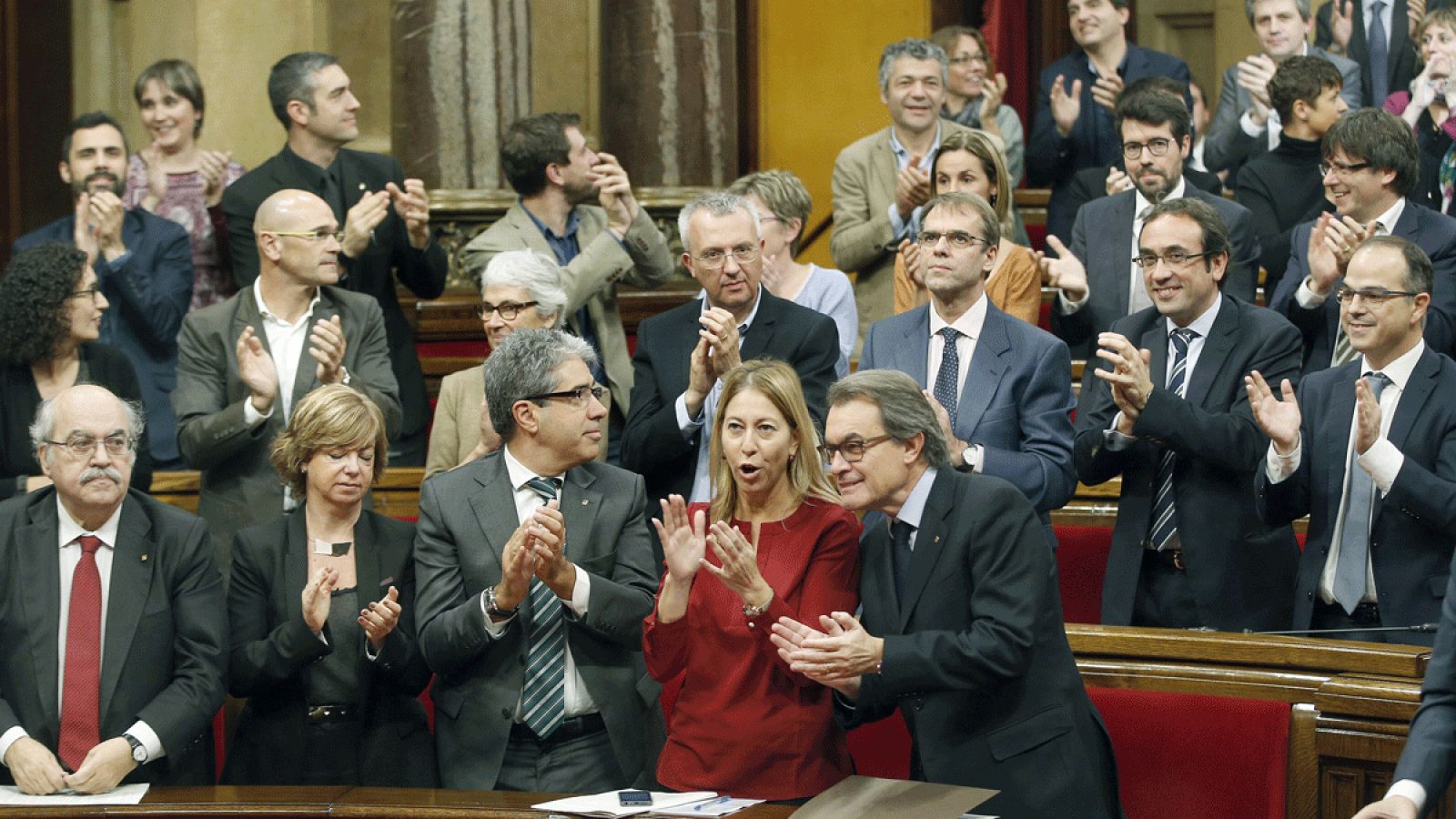 El expresidente de la Generalitat, Artur Mas, aplaude junto a miembros de su Gobierno tras la aprobación de la declaración rupturista del 9N