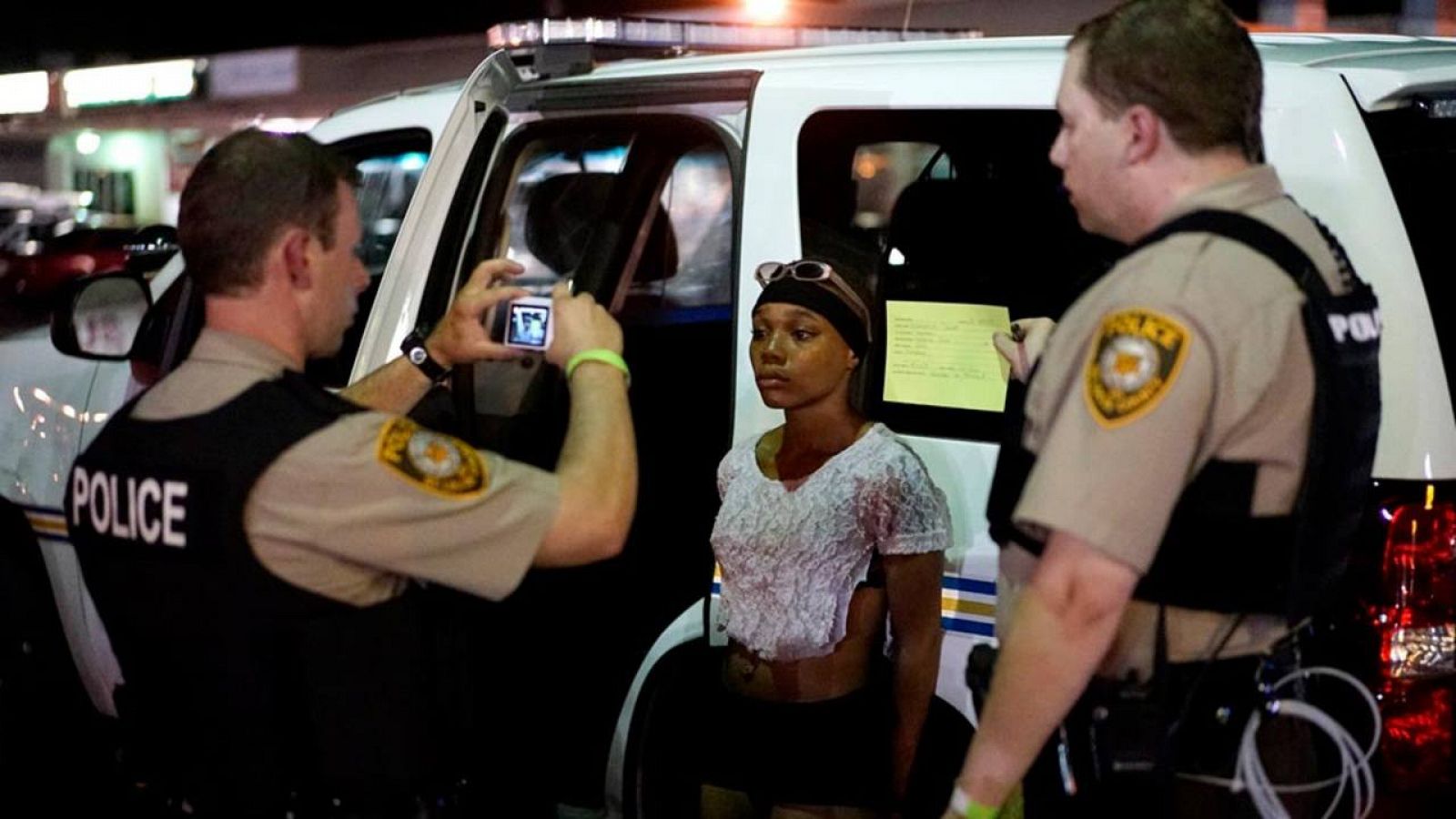 Un policía toma una foto a una mujer que protestaba contra la violencia racial el pasado verano