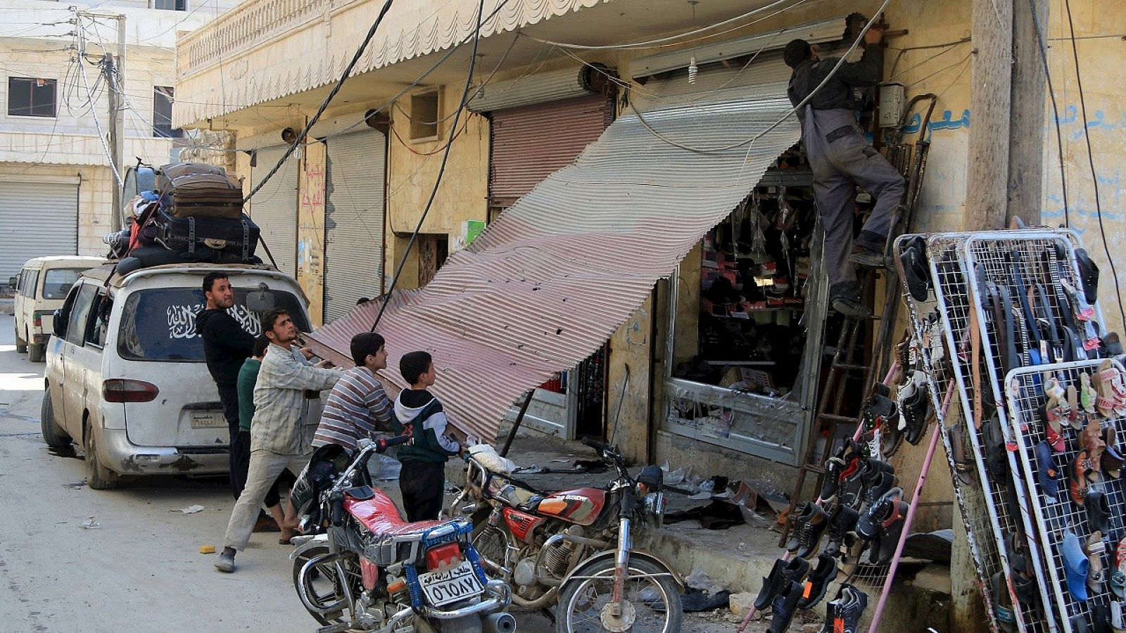 Habitantes de Darat Izza, en la provincia de Alepo, en Siria, intentan reparar los daños causados por los enfrentamientos. REUTERS/Ammar Abdullah