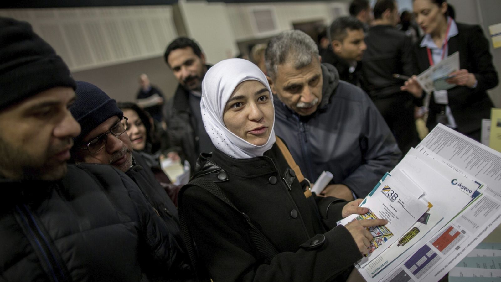 Una joven siria de 26 años lee una oferta de trabajo mientras visita una feria de empleo para refugiados en Berlín