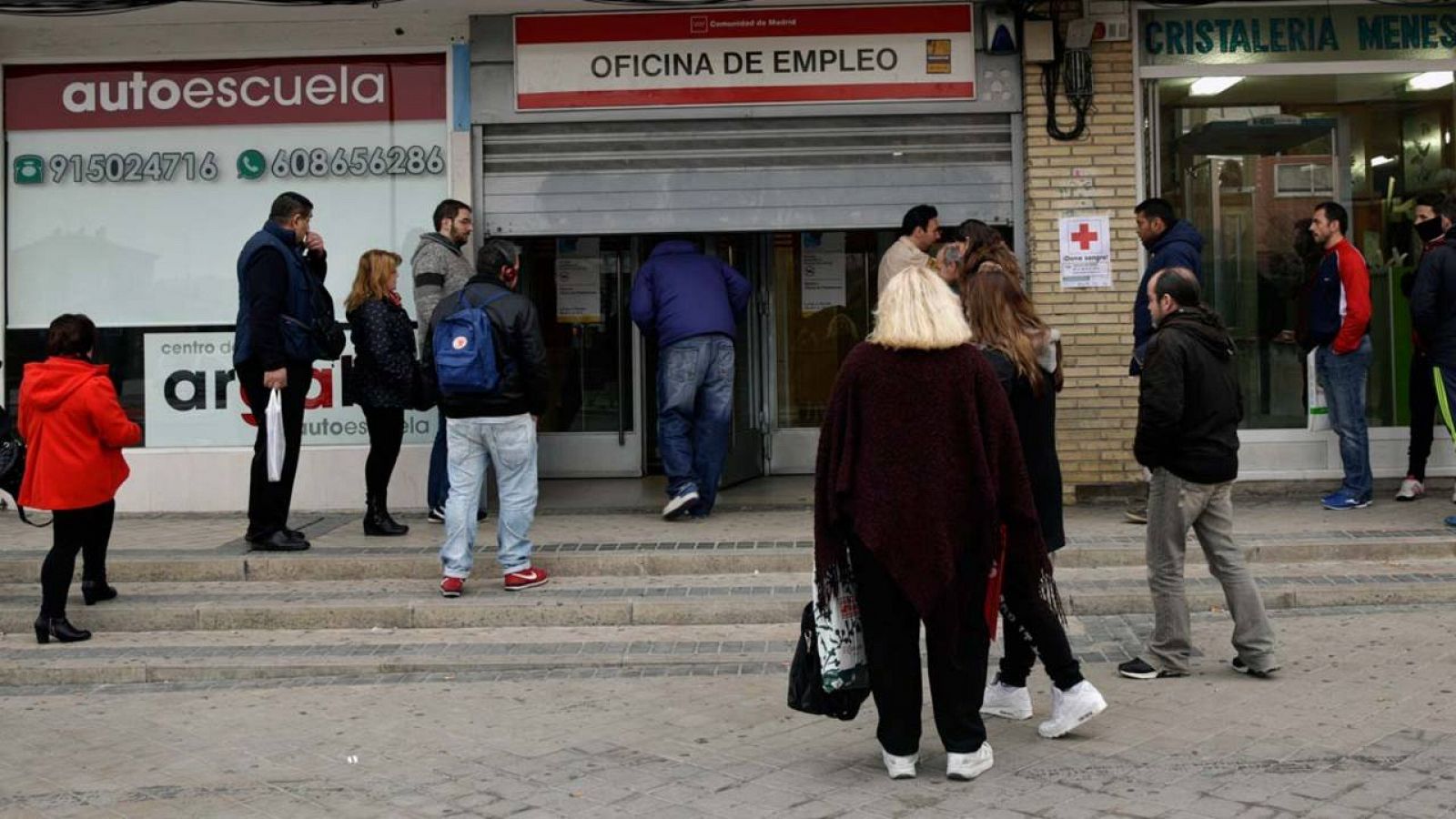 Varias personas esperan para entrar en una oficina de empleo en Madrid